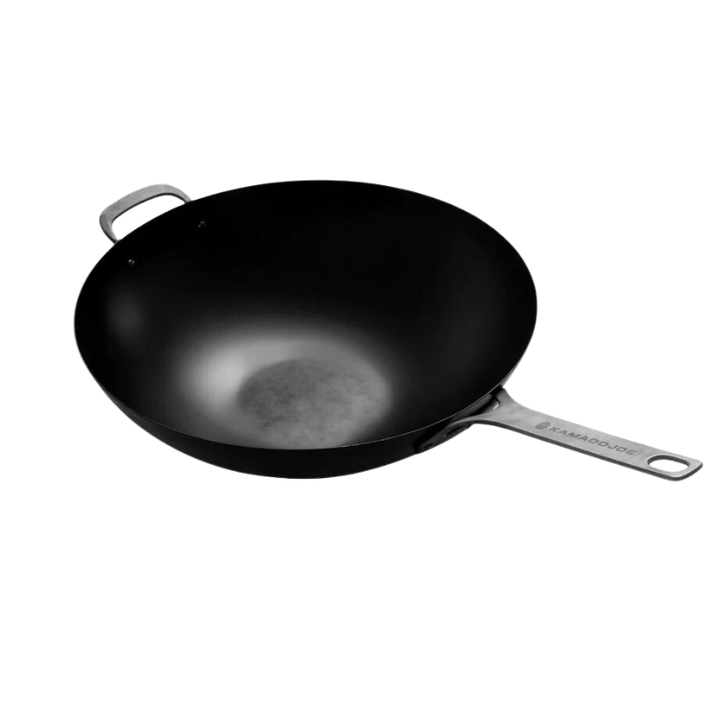 A black carbon steel wok with stainless-steel handles, designed for use on a Kamado Joe ceramic grill.