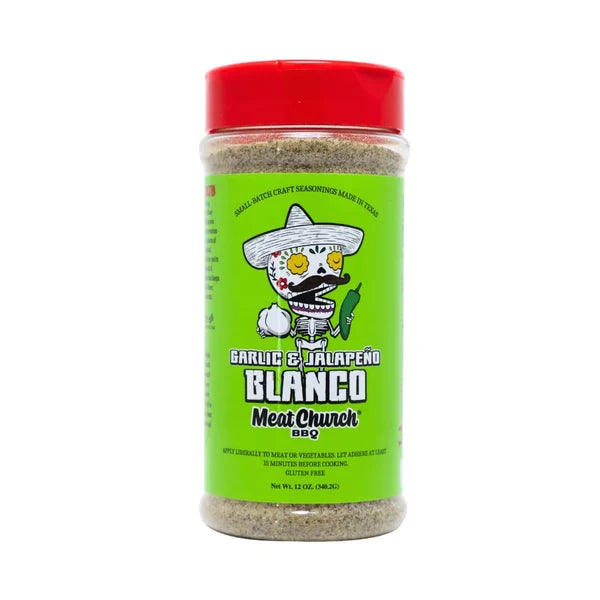 A 12 oz plastic jar of Meat Church BBQ Garlic & Jalapeño Blanco seasoning blend, featuring a bright green label with a cartoon skeleton chef and a red lid, set against a plain white background.