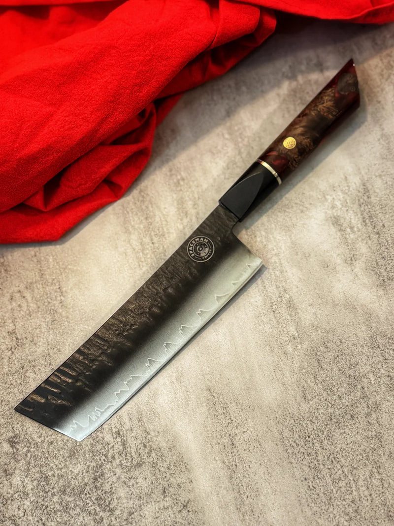 Knife with a wooden handle on a textured surface next to red fabric
