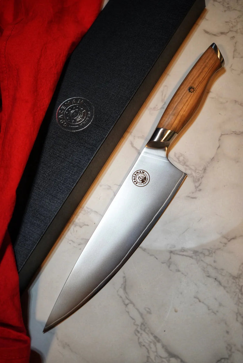 Knife with wooden handle and metal blade on a marble surface