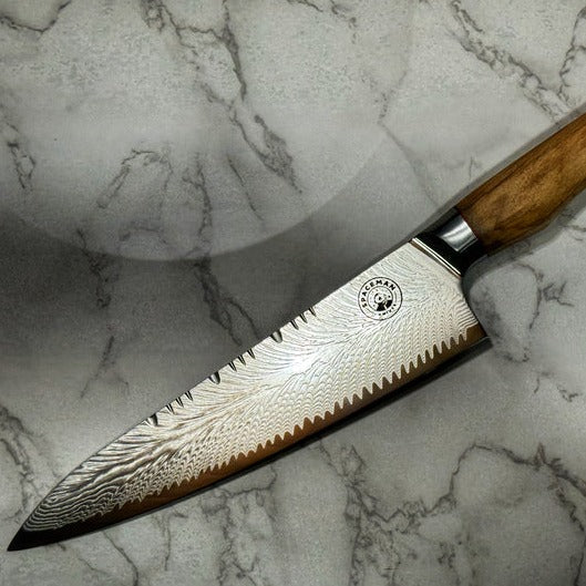 Damascus Style Chef knife with a wooden handle on a marble background