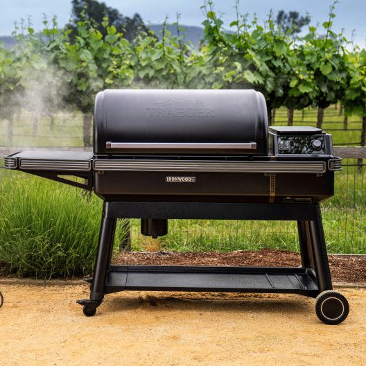 Black grill on a patio with a vineyard in the background