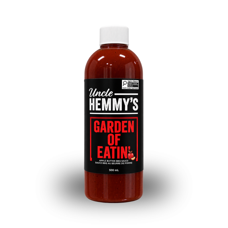 A 500 mL bottle of Uncle HEMMY'S Garden of Eatin' apple butter barbecue sauce, featuring a black label with bold red and white text, filled with reddish-brown sauce and topped with a white cap, set against a plain white background.