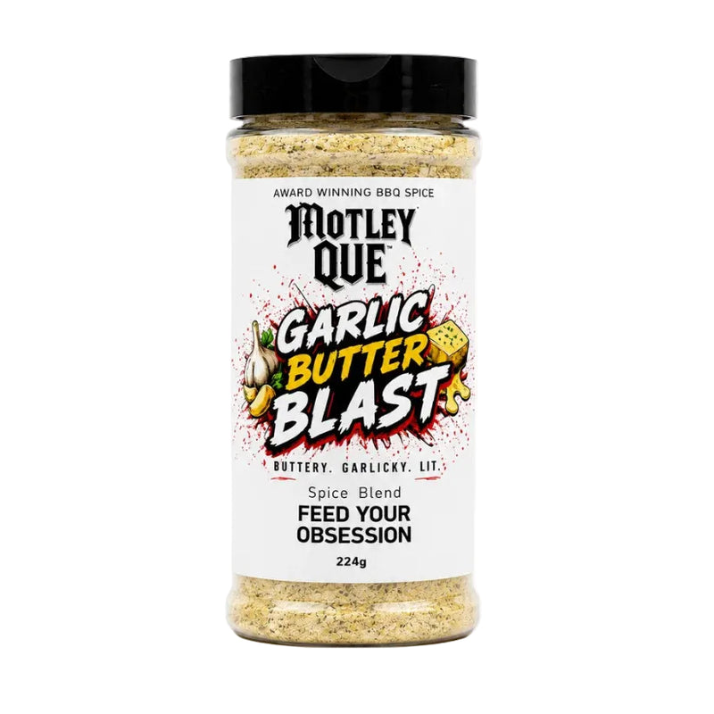 A bottle of Motley Que Garlic Butter Blast spice blend on a clean white background. The clear plastic bottle shows the textured yellowish-brown spice blend inside, topped with a black lid and featuring a white label with colorful graphics.