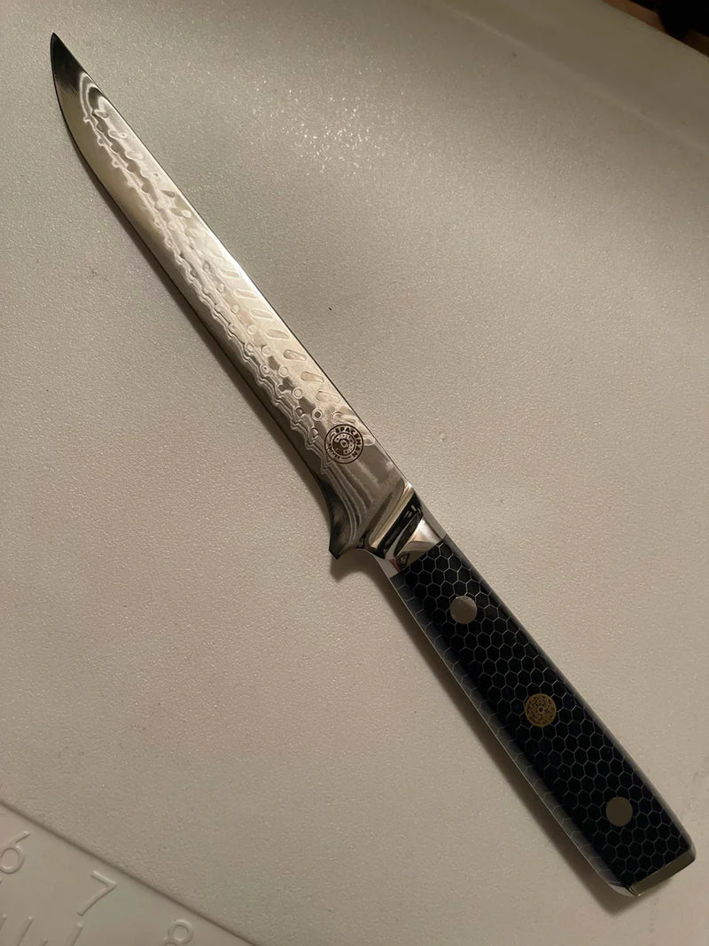 Decorative knife with a textured blade on a light gray surface