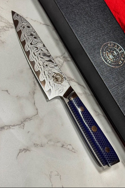 Decorative chef's knife with blue handle on a marble surface